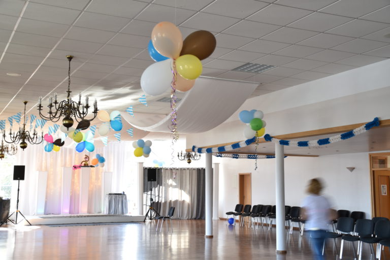 Festlich dekorierter Tisch im Festsaal Vernissage in Quakenbrück mit elegantem Geschirr, Blumenarrangements und Kerzen für eine stilvolle Geburtstagsfeier.